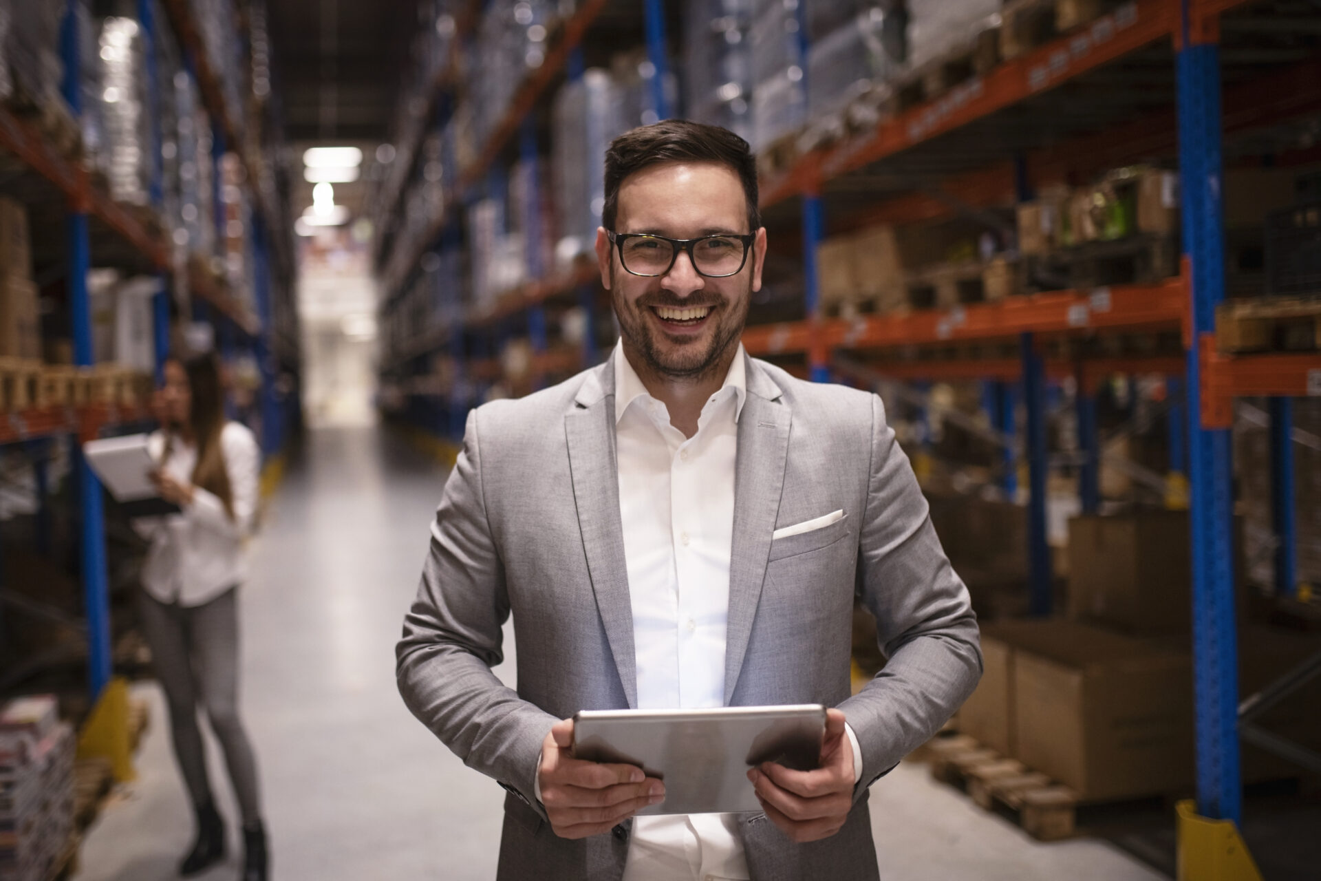 CEO Handelsunternehmen cheerful successful middle aged manager businessman holding tablet computer large warehouse organizing distribution